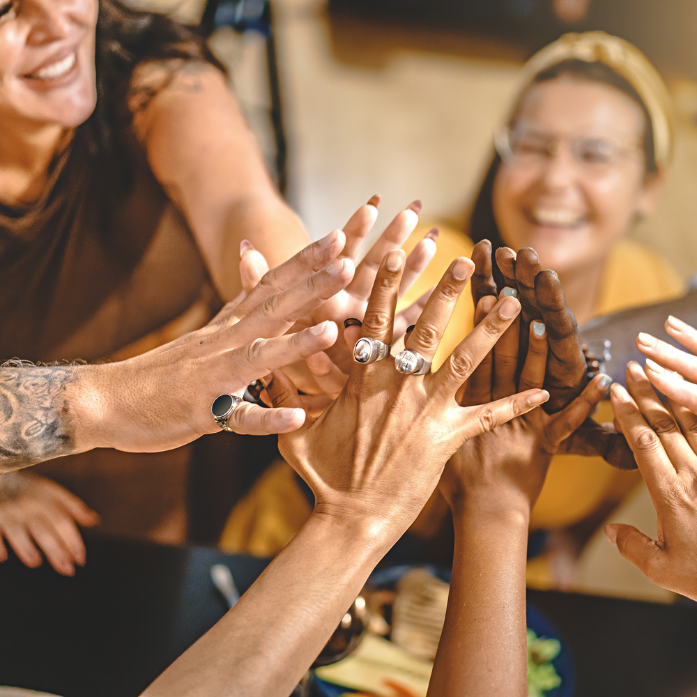 Salon team members joining hands together in a supportive team moment